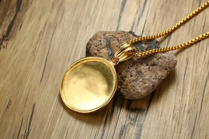 Detailed shot of a gold-toned circular pendant tray on a stylish box chain necklace