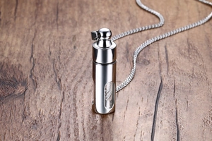 Détail du pendentif cylindrique en acier inoxydable argenté avec fenêtre sur bois
