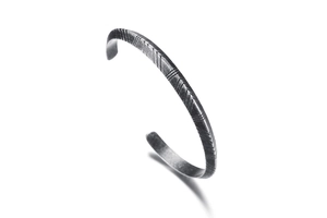 Detailed close-up of 6mm vintage grey stainless steel cuff with engraved geometric patterns
