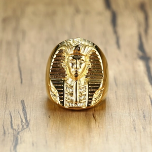 Golden stainless steel Egyptian Pharaoh signet ring for men on a wood surface
