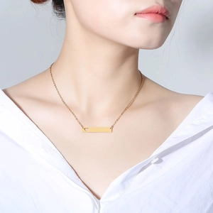Minimalist gold square bar necklace with hollow heart worn by model on white shirt