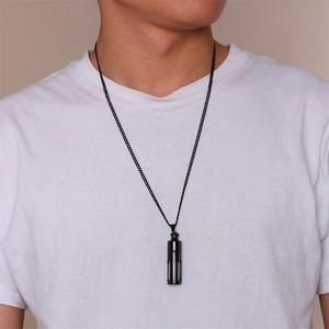Vue détaillée du collier pendentif cylindrique en acier noir minimaliste sur mannequin