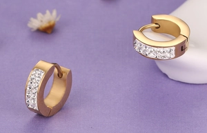 Vue détaillée de boucles d'oreilles créoles dorées ornées de deux rangées de strass brillants