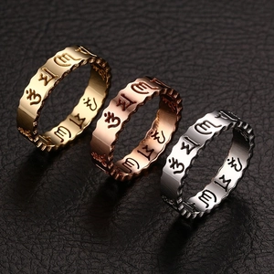 Three-color stainless steel rings with engraved mantras and scalloped edges on leather