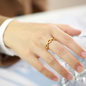 Close-up of golden stainless steel chain ring on finger with modern minimalist style
