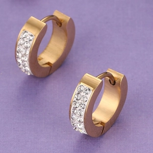 Boucles d'oreilles créoles dorées avec double rangée de strass blancs sur fond violet