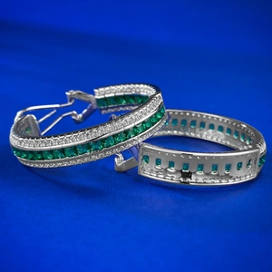 Macro view of silver emerald hoop earrings with square green stones and white pavé zircons