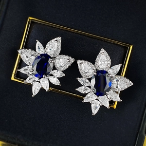 Close-up of S925 silver flower stud earrings with 2ct oval blue corundum and zircons