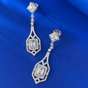 Macro shot of emerald-cut white zircon silver earrings with micro-pave small diamonds