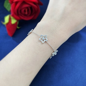Detail of silver S925 hollow flower bracelet with pavé zircons on a model's wrist