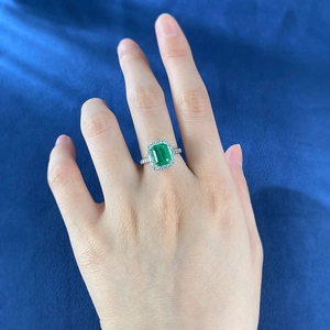 Detailed macro view of S925 silver emerald cut ring on dark blue velvet background