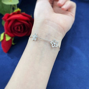 Detail of S925 silver double flower bracelet with pavé diamonds on a model's wrist