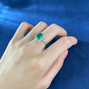 Detail of S925 silver ring featuring a 2-carat emerald-cut green stone and diamond halo