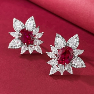 Macro shot of S925 silver stud earrings with oval red corundum and petal-shaped stones