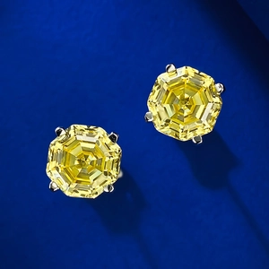 Macro view of octagonal step-cut yellow gemstones in 4-prong silver stud settings