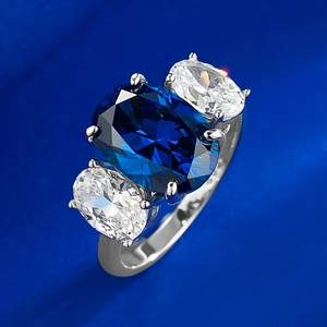 Macro shot of oval royal blue stone and side diamonds in a silver four-prong setting