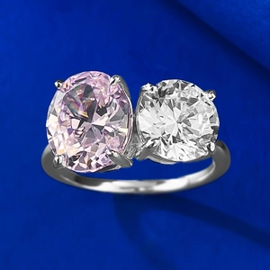 Detail of a Toi et Moi ring with oval pink gem and round white stone in four-prong setting