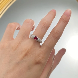 Macro view of a 925 silver ring featuring a heart-cut ruby with full pave diamond accents