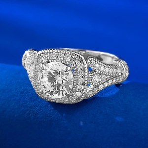 Gros plan d'une bague avec diamant rond à double halo et pavé sur large anneau argenté