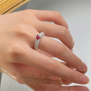 Macro shot of a 925 silver ring featuring a heart-shaped ruby center and pavé diamonds