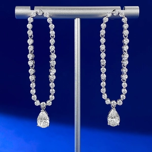 925 silver pear cut drop earrings with round clear stones on a professional display stand