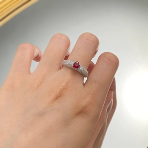 Close-up of heart-shaped pigeon blood red gemstone ring with micro-pave diamond accents