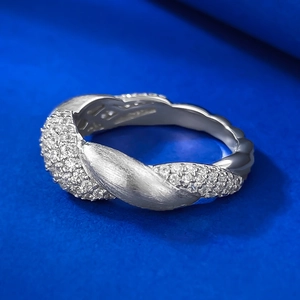 Macro detail of S925 silver flower ring featuring pavé diamonds and brushed texture