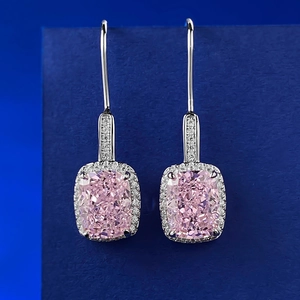 Detailed view of cushion-cut pink gemstone earrings with halo setting in silver hooks