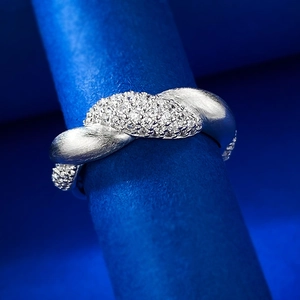 Macro shot of S925 silver flower ring with diamond pavé and brushed metal finish