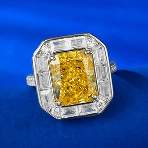 Macro detail of radiant cut yellow gemstone ring with side baguette diamond accents