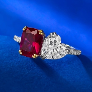 Macro shot of a Toi et Moi ring featuring a red cushion gemstone and heart-shaped diamond