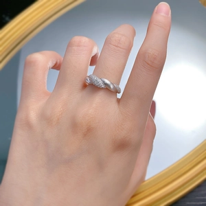 Macro detail of S925 silver flower ring showing brushed matte texture and micro-pave zircons