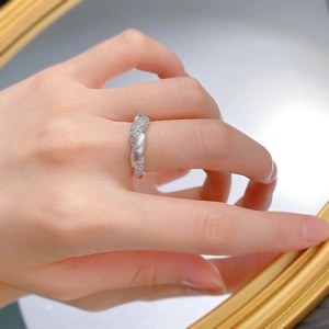Detail of S925 silver flower ring with brushed texture and pavé set cubic zirconia
