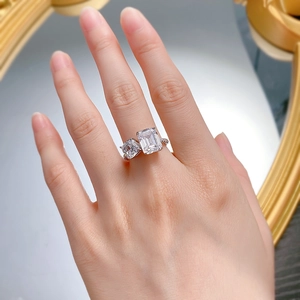 Detail of silver twisted band ring with emerald and cushion cut cubic zirconia stones