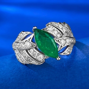 Macro shot of S925 silver ring featuring marquise emerald and diamond leaf detail