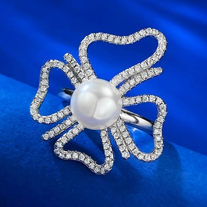 Détail d'une bague perle 8mm et pétales de diamants sur fond de velours bleu