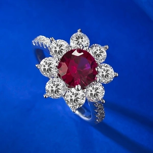 Vue macro d'une bague fleur avec pierre rouge centrale et pétales en zircon blanc