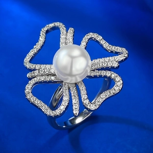 Gros plan sur bague perle naturelle 8mm avec monture fleur creuse et design argent