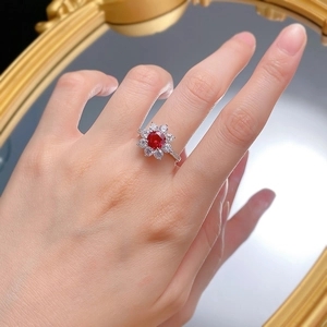 Bague élégante en argent avec rubis central et halo de zirconiums dans un reflet miroir
