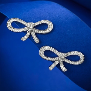 Elegant S925 sterling silver bow stud earrings with sparkling zircon stones on blue base