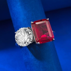Macro shot of Toi et Moi silver ring with emerald-cut red stone and round white gem