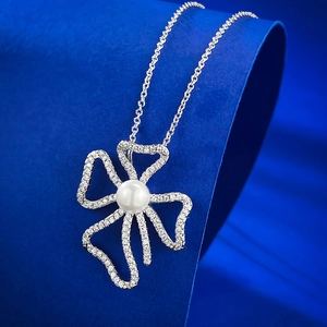 Elegant 925 silver necklace with 8mm natural pearl and zircon bow pendant on blue background