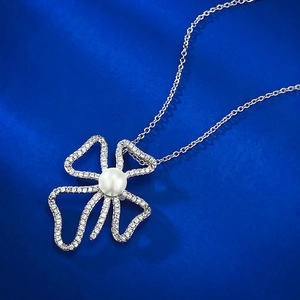 Macro view of a 925 silver 8mm pearl pendant with a CZ-studded abstract floral design