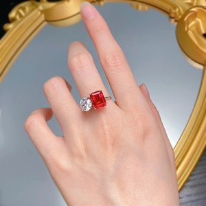 Detail of red emerald-cut stone and white round zircon in silver double stone ring