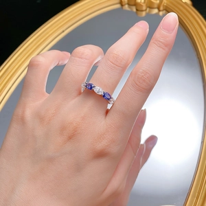 Détail d'une bague en argent S925 avec cinq pierres ovales bleues et blanches sur miroir