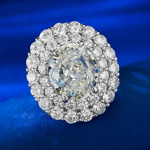 Macro shot of oval cut diamond ring with double halo setting on blue fabric