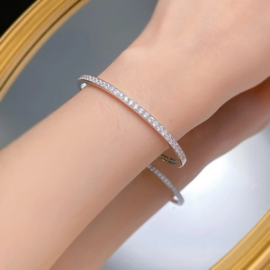Minimalist S925 sterling silver pave-set diamond bracelet on a woman wrist with reflection