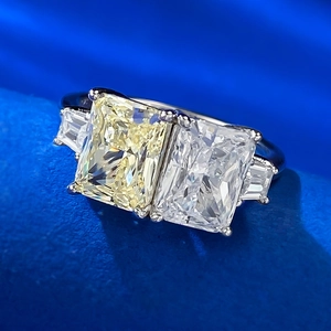Primer plano de anillo Toi et Moi con diamantes amarillos y blancos en terciopelo azul