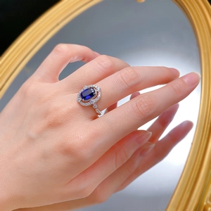 Close-up of vintage S925 silver ring with oval blue gemstone and halo of white diamonds