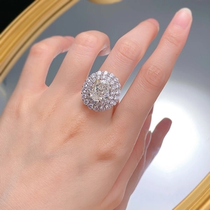 Luxurious double halo oval cut carbon diamond ring in silver finish on a finger